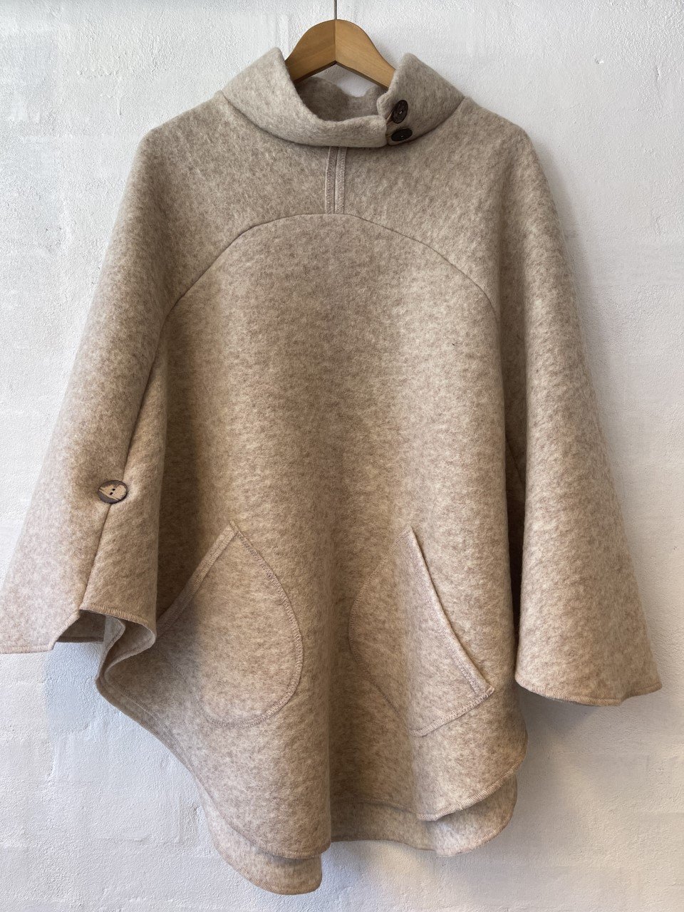 Poncho med asymmetrisk krave. Creme. Ponchoer uldkompagniet.dk